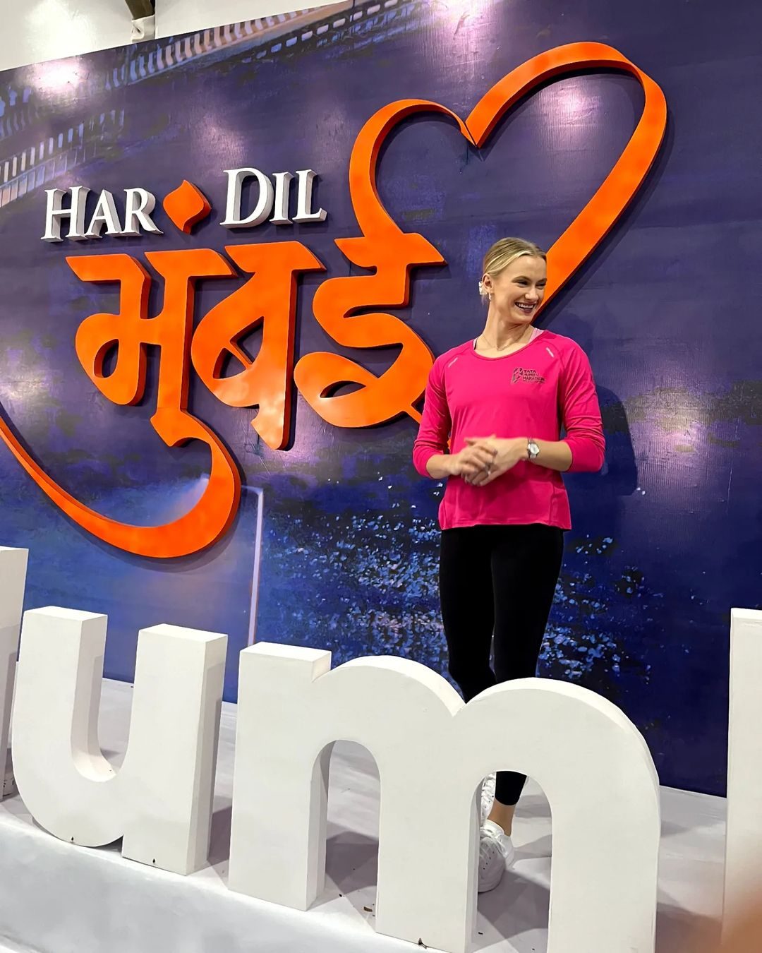 Katie Moon at the Tata Mumbai Marathon expo, against the Har Dil Mumbai backdrop